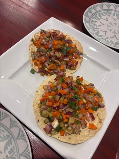 Masala papad topped with chopped onion, carrot, cucumber and cilantro